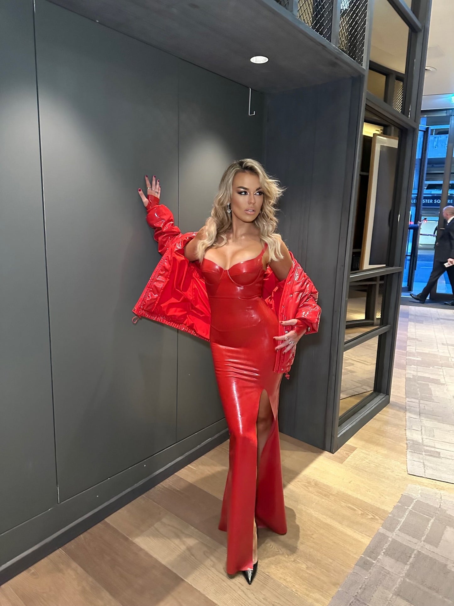 High-shine cupped latex dress with structured bust and front slit, worn by Talia Storm